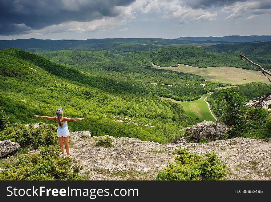 Young woman enjoying the storm at the edge of the cliff, Crimea, Ukraine. Young woman enjoying the storm at the edge of the cliff, Crimea, Ukraine