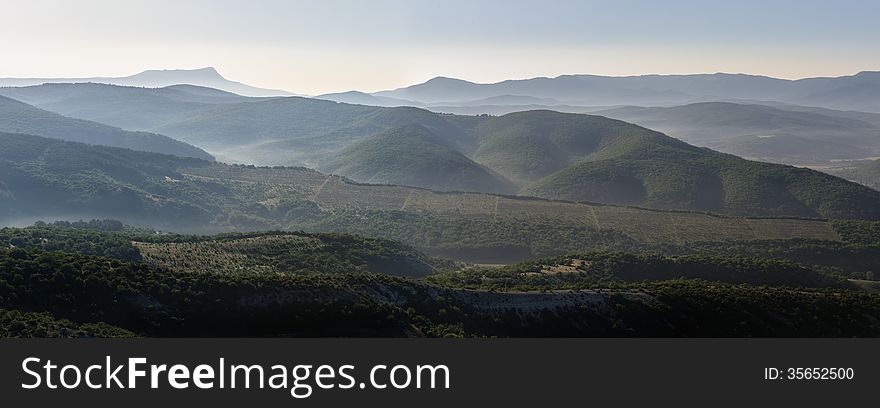 Landscape, sunrise over foggy hills, panorama stitched from 3 frames