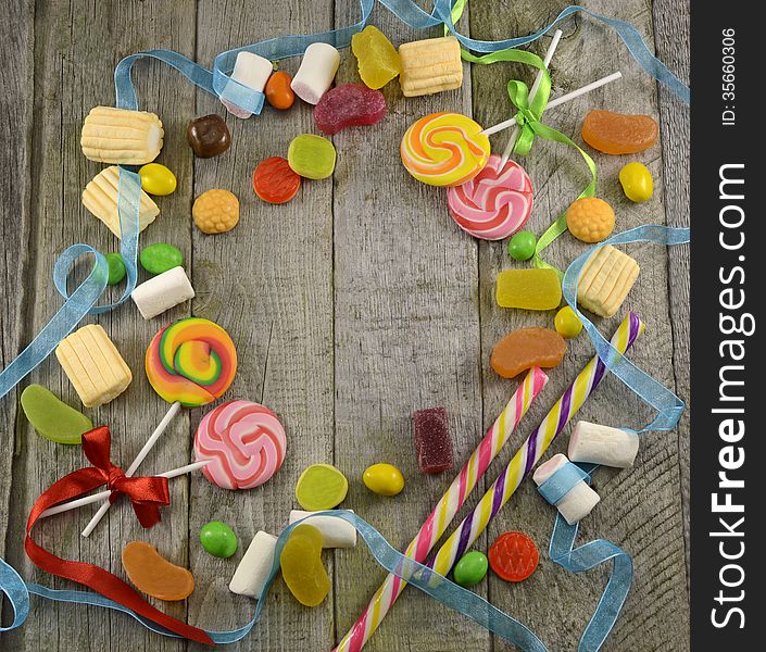 Round border with sweet things and ribbon on wood. Round border with sweet things and ribbon on wood