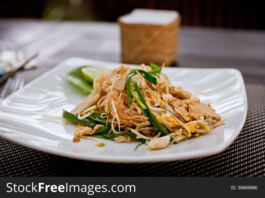 Plate with typically asian noodle dish with eggs and chicken