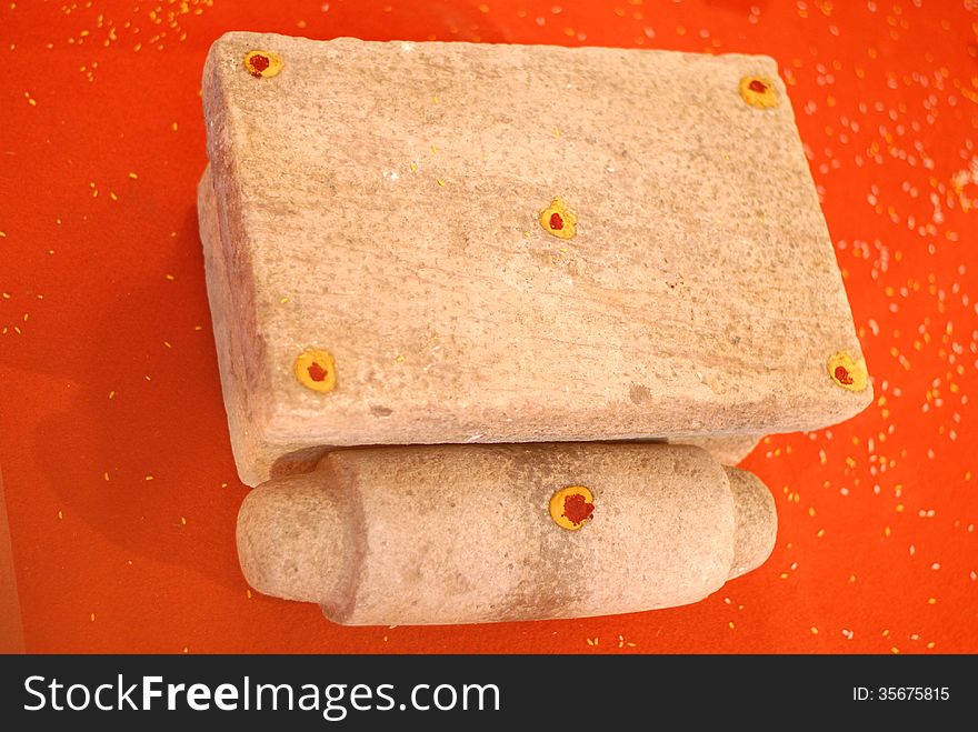 A grinmding stone with roller stone which is used in indian hindu wedding culture as a traditionto place the couples foot on the stone. A grinmding stone with roller stone which is used in indian hindu wedding culture as a traditionto place the couples foot on the stone