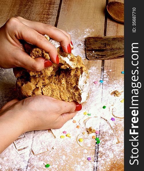 Hands of Women with Red Manicure Making Gingerbread Dough with Flour, Kitchen Utensils and Sweet Decoration on Wooden background. Hands of Women with Red Manicure Making Gingerbread Dough with Flour, Kitchen Utensils and Sweet Decoration on Wooden background