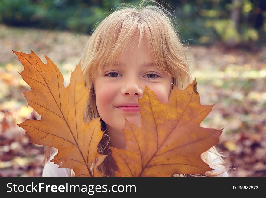 A little girl lying in autumn leaves. A little girl lying in autumn leaves.