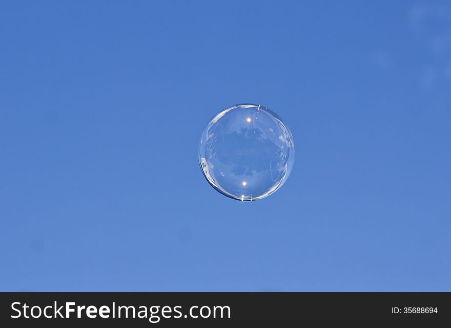 A clear soap bubble against a blue sky. A clear soap bubble against a blue sky