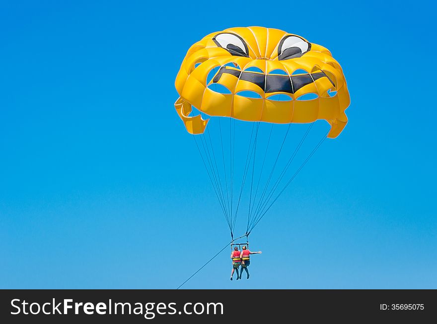 Yellow parachute on blue sky