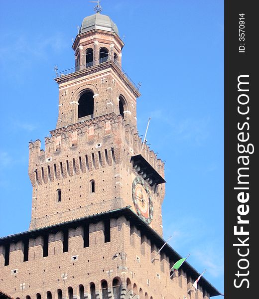 The bell tower of the castle sforzesco in Milan under a blue sky. The bell tower of the castle sforzesco in Milan under a blue sky