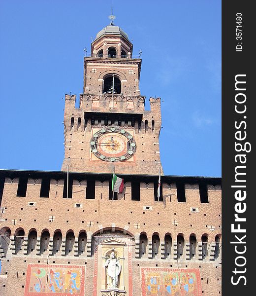 The bell tower of the castle sforzesco in Milan under a blue sky and sunlights