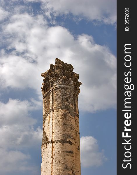 A high harmonous column in ancient port Caesaria on a background of the cloudy sky. A high harmonous column in ancient port Caesaria on a background of the cloudy sky