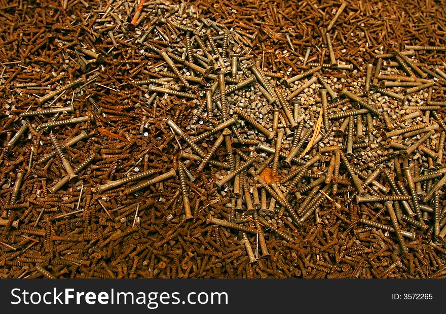 Heap of isolated rusty screws