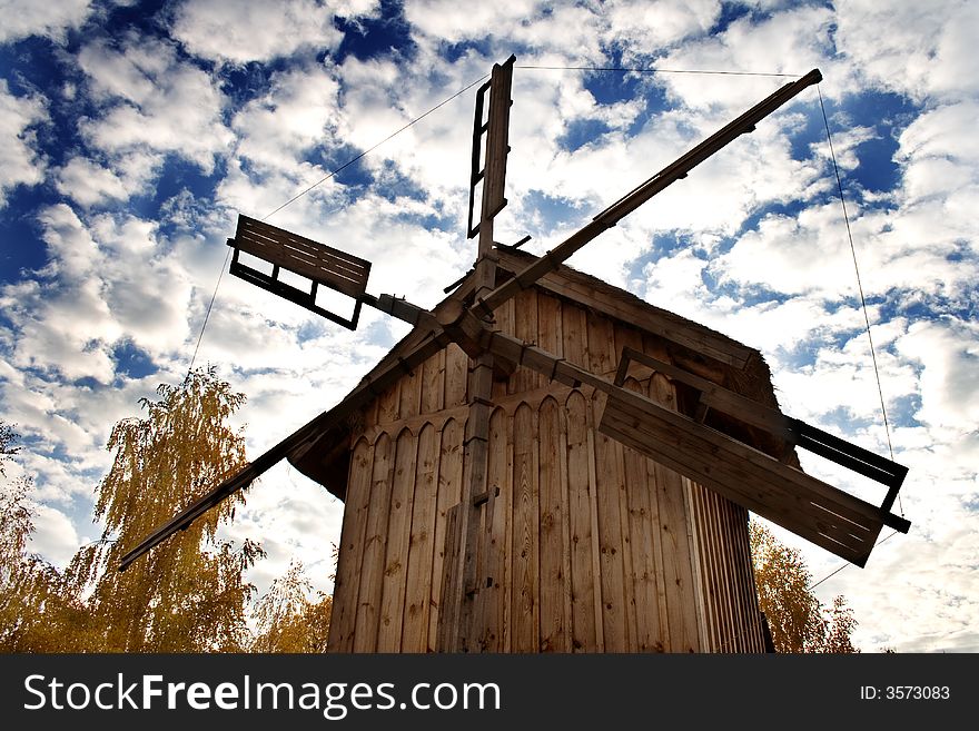 Old-styled windmill against cloudy sky