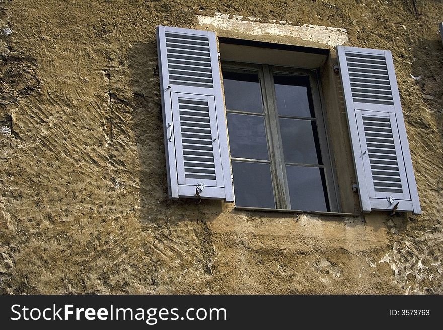 Window with gray shutters in the ancient house