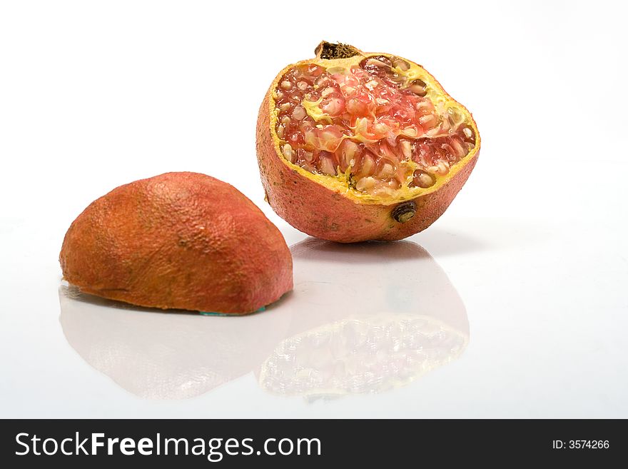 Two halves of juicy pomegranate isolated on white with reflection