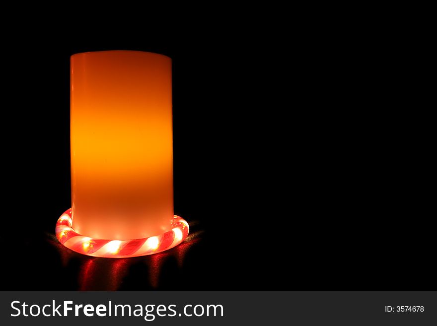 An Electric Candle on black background with candy cane light