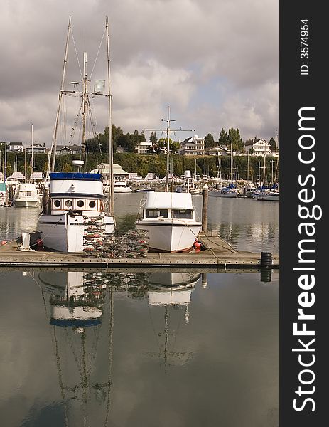 Two fishing boats at a busy marina