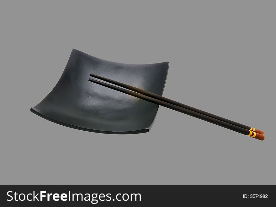 Black Japanese sticks and dish on a grey background. Black Japanese sticks and dish on a grey background