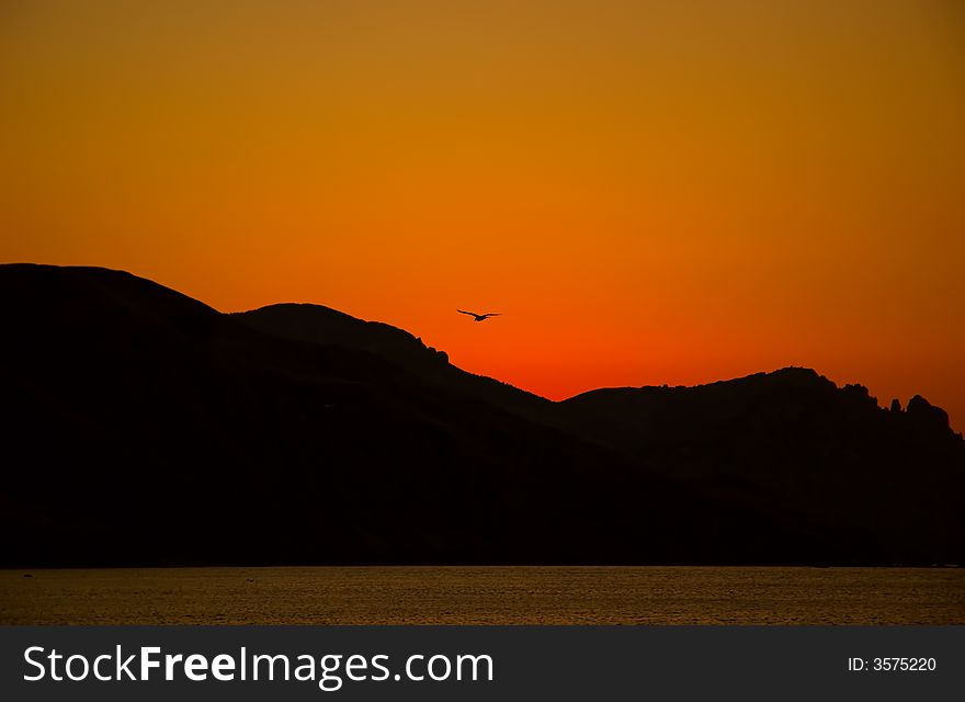 Orange sunrise from mountains and sea