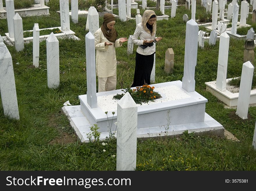Two young female muslim girls on cemetery