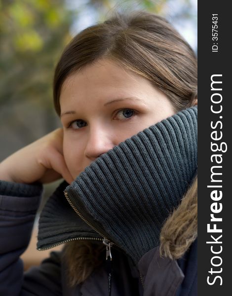 Young caucasian female hiding her face behind a parka. Soft focus. Young caucasian female hiding her face behind a parka. Soft focus.