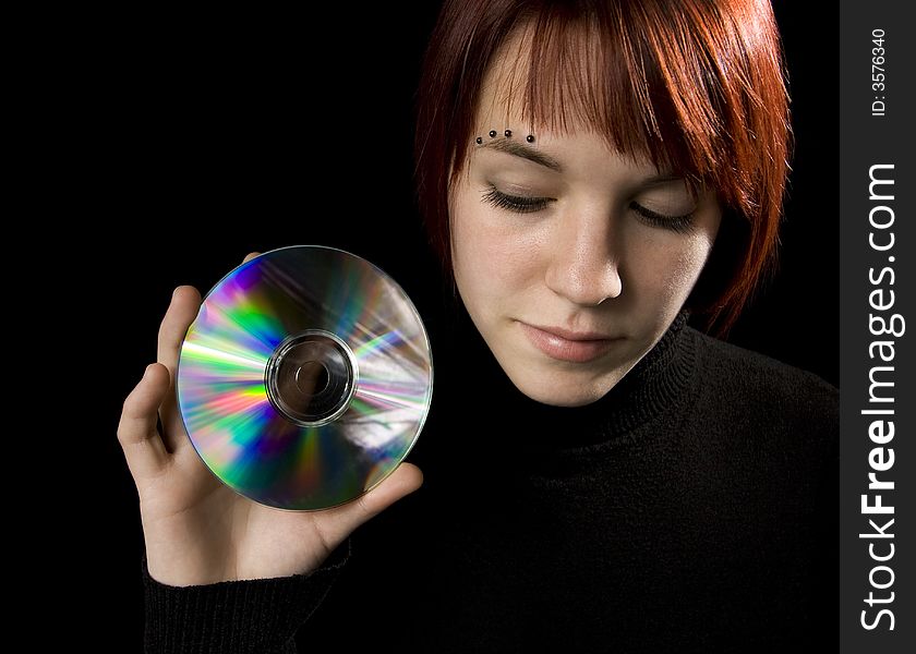 Redhead girl holding a compact disc.

Lit with studio lighting hair light and two umbrelled strobes.