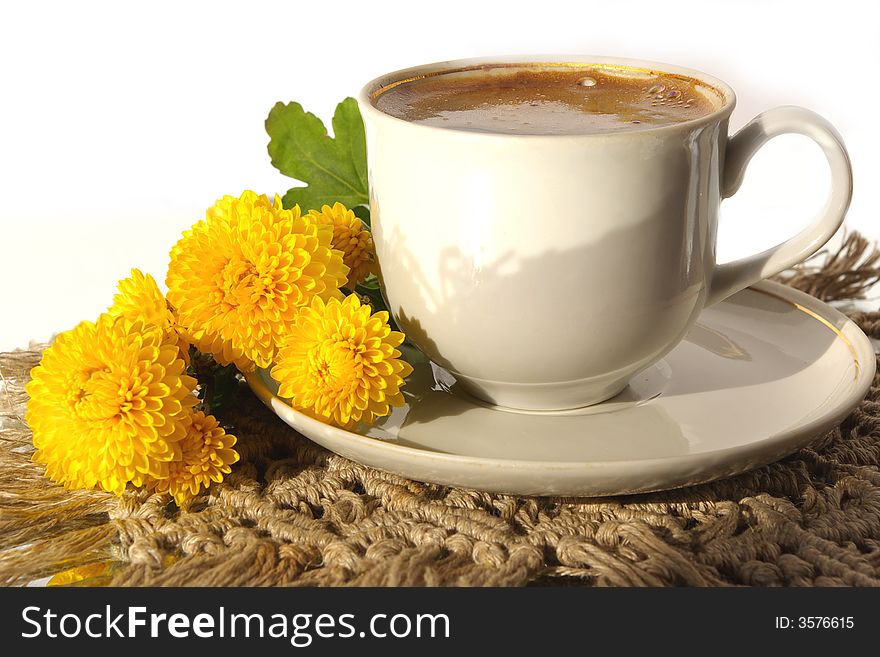 A cup of coffee and yellow flower. A cup of coffee and yellow flower