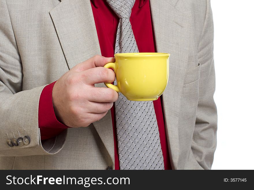 The man holds a yellow cup with tea. The man holds a yellow cup with tea