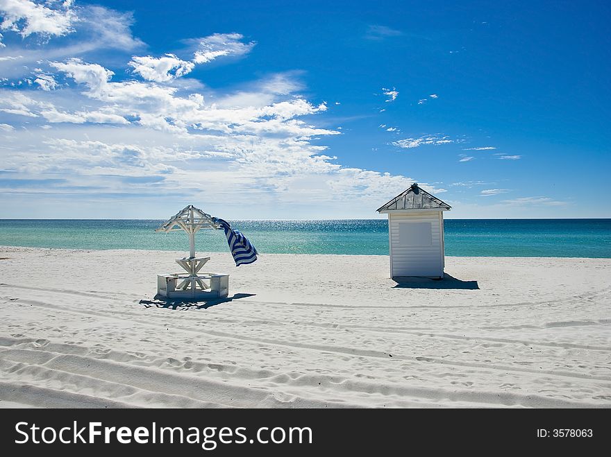 Picture of a shed and a beach umbrella on a beach facing the sea signifying relaxation. Picture of a shed and a beach umbrella on a beach facing the sea signifying relaxation