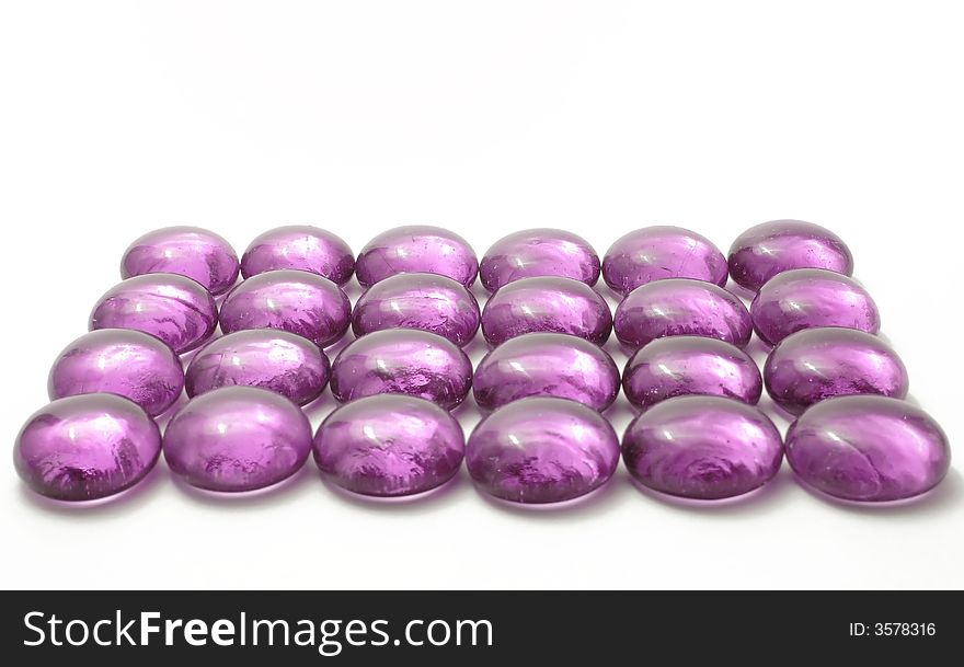 Violet glass pebbles on the white background