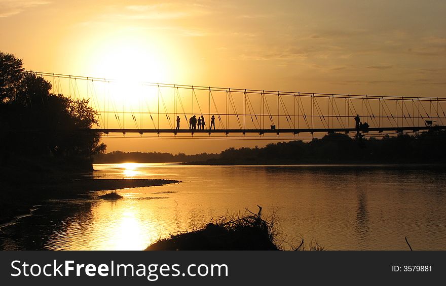 Sunset moment at riverside rope bridge & tourist people. Sunset moment at riverside rope bridge & tourist people