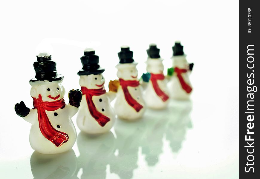 Row of small snowmen over a white background. Row of small snowmen over a white background