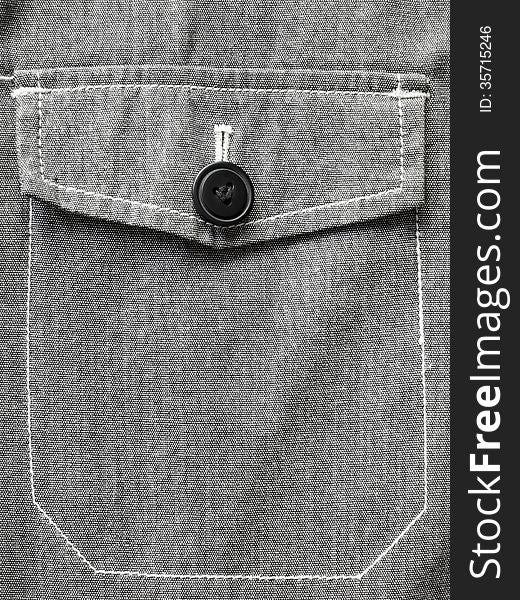 Gray jacket pocket closed on black button. Gray jacket pocket closed on black button