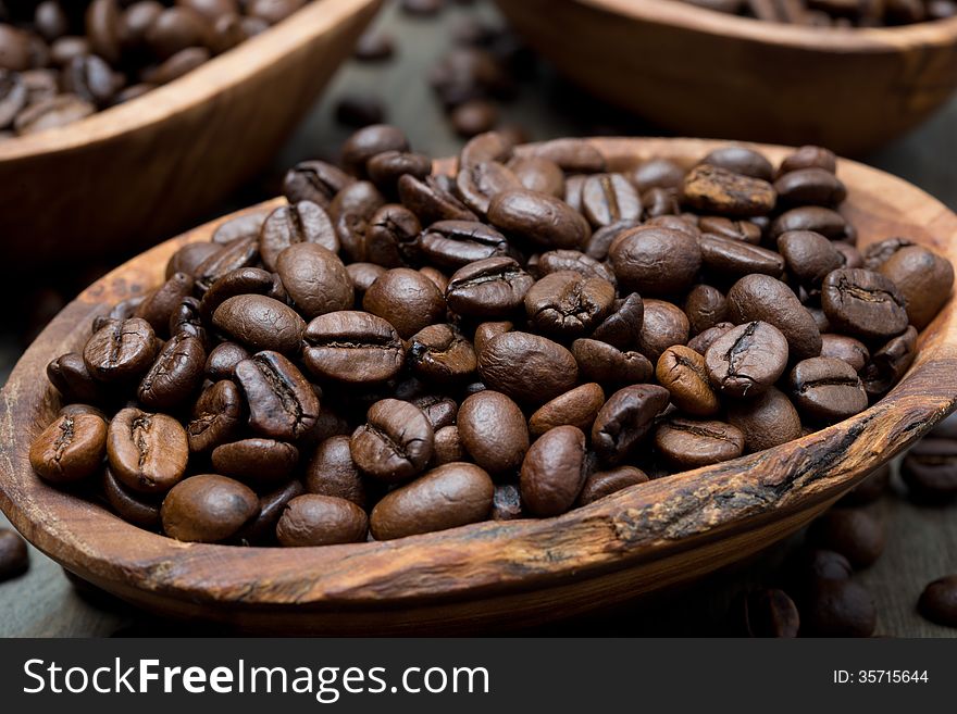 Coffee beans in a wooden bowl, close-up, horizontal. Coffee beans in a wooden bowl, close-up, horizontal