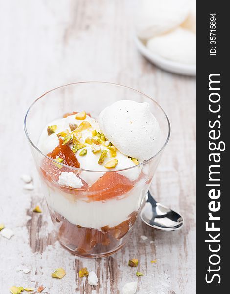 Dessert with canned peaches, whipped cream and meringue, top view, vertical. Dessert with canned peaches, whipped cream and meringue, top view, vertical