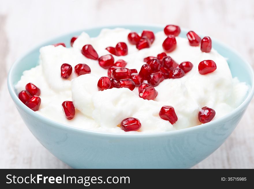 Homemade yogurt with pomegranate seeds, close-up