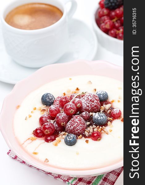 Semolina porridge with fresh berries, nuts and coffee for breakfast, close-up, vertical