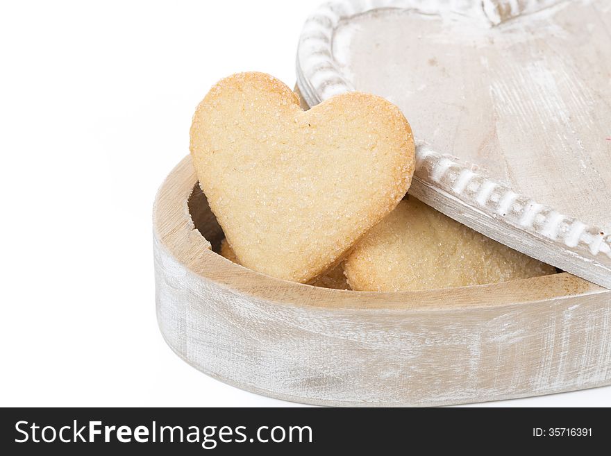 Wooden box with cookies in the form of heart, isolated on white