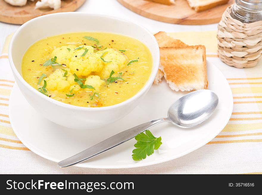 Cauliflower soup with curry and cream in a bowl