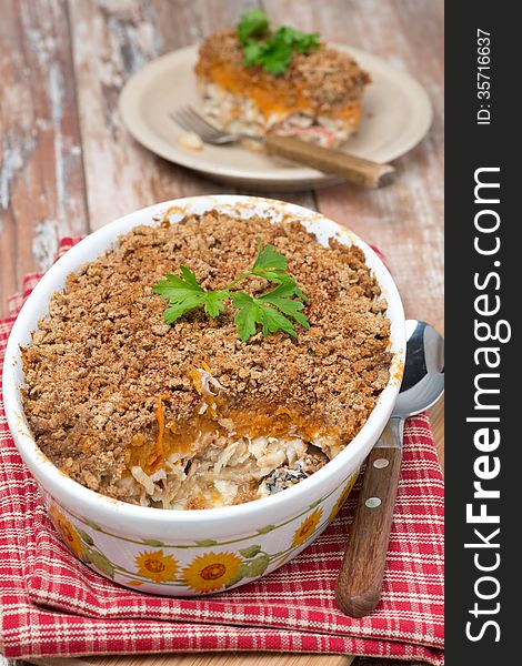 Gratin with fish and pumpkin in a ceramic form, vertical