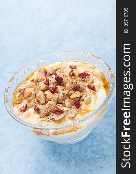 Homemade natural yogurt with maple syrup, granola and nuts, vertical, close-up