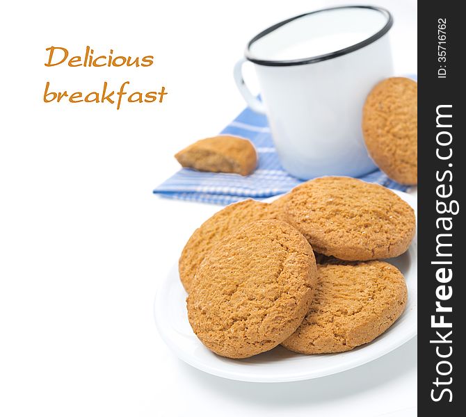 Plate of oatmeal cookies and mug of milk isolated on white, close-up