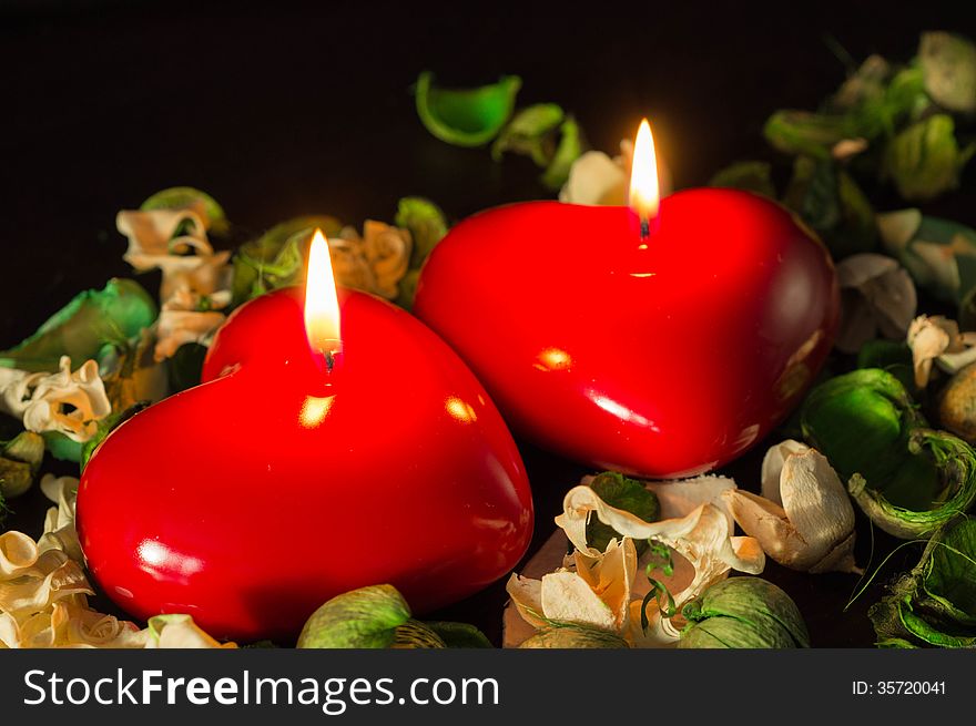 Couple of red candles among the dried flowers close up