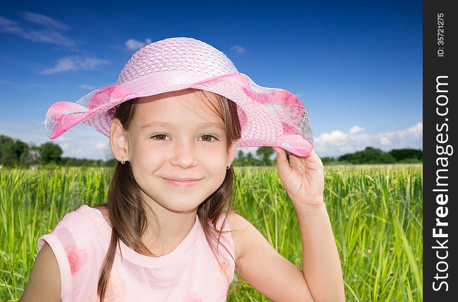 Ð¡ute little girl straightens her bonnet. Ð¡ute little girl straightens her bonnet