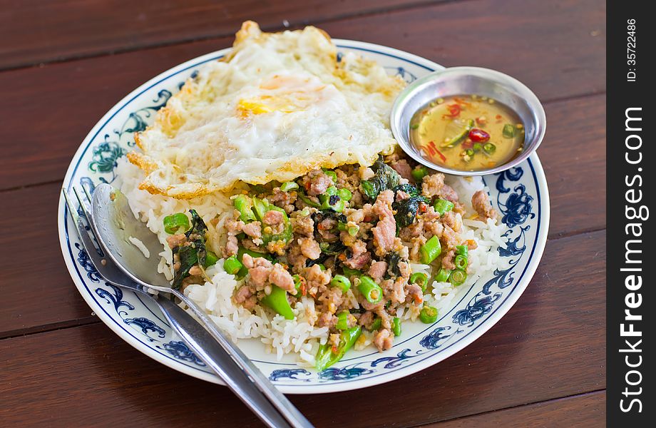 Stir fried pork with basil and egg on rice