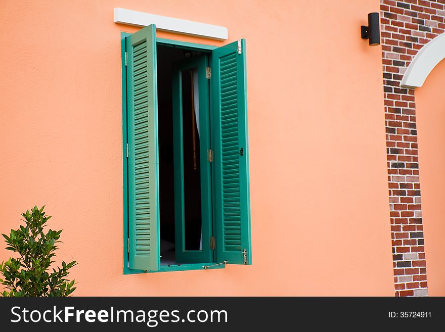 Green window is open on pink wall. Green window is open on pink wall