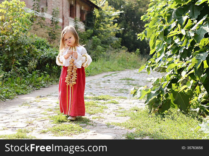 Little girl in russian national costume goes on road. Little girl in russian national costume goes on road