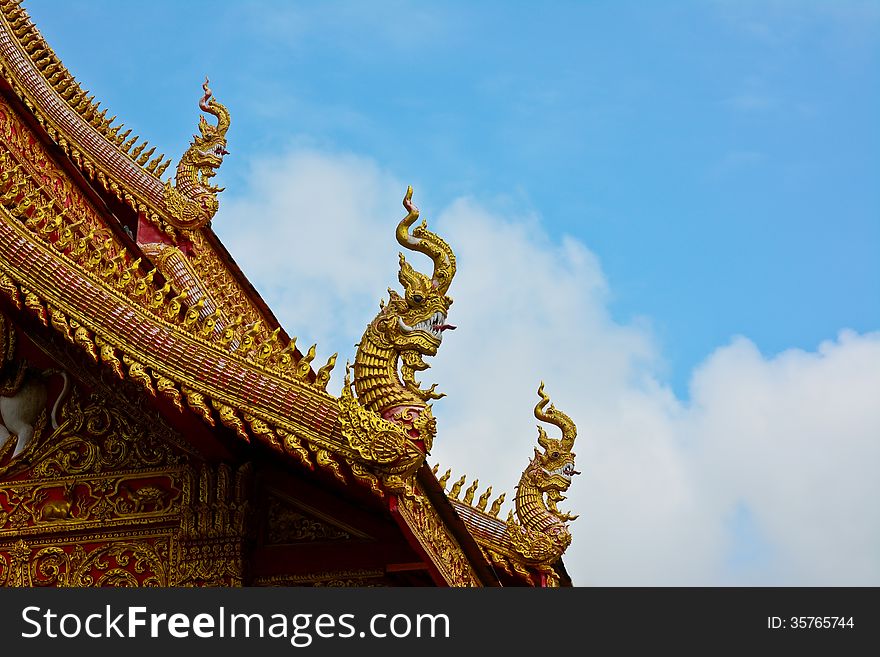 Roof style of thai temple that decorate with naga and blue sky background