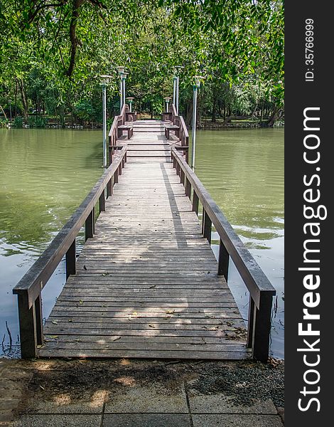 Walkway wooden bridge over pond on park of silpakorn university, Nakhonpathom