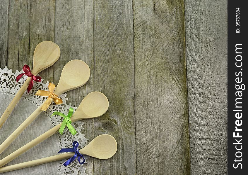 Four spoons with colorful bows on wooden background. Four spoons with colorful bows on wooden background