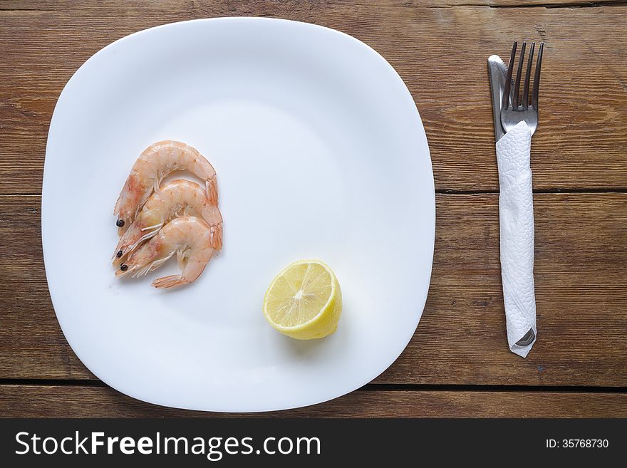 Served white dish with shrimps and lemon. Served white dish with shrimps and lemon