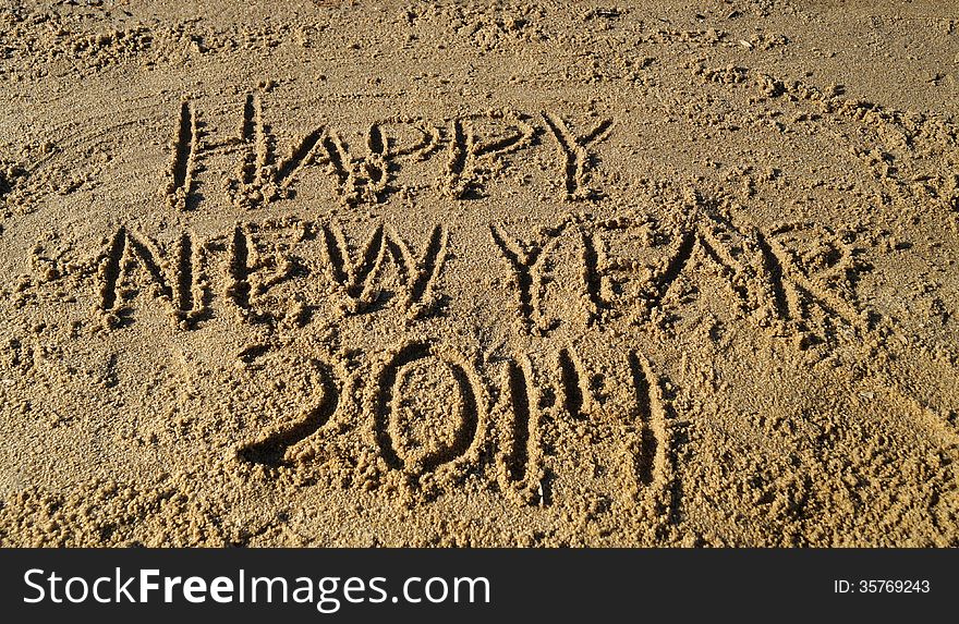 The words Happy New Year 2014 written in sand on the beach. The words Happy New Year 2014 written in sand on the beach