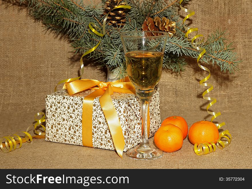 A glass of champagne, tangerines and present for the new year